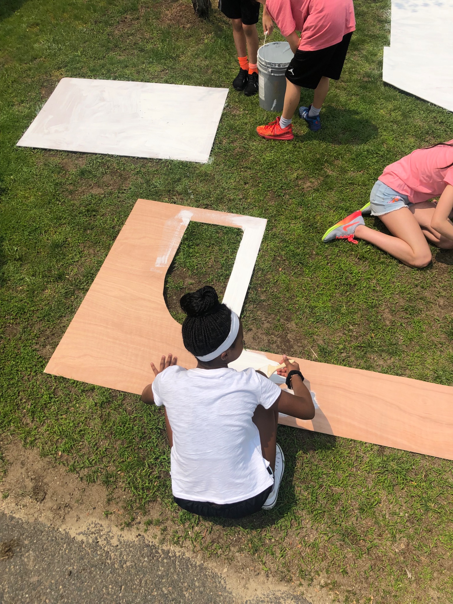 Students painting the plywood panels for their food trucks